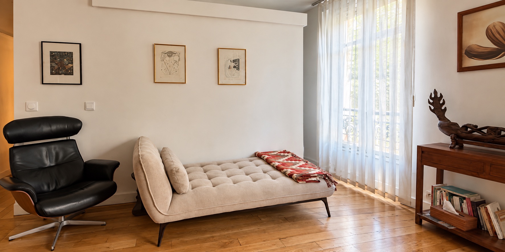 Cabinet de psychanalyse avec fauteuil noir et divan